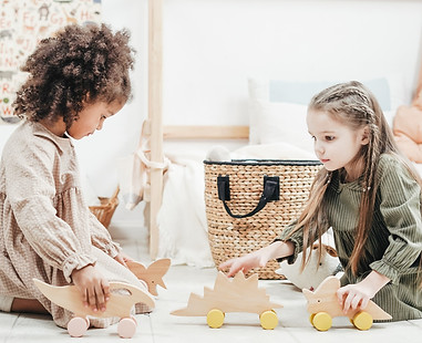 Zwei Mädchen spielen mit Holzspielzeugen