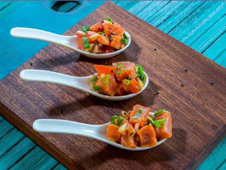 Three white Japanese soup spoons with scoops of Copper River sockeye lomi lomi.