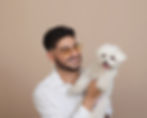 Armin Farshchi, founder of Miami Rugs, holding a small white dog.
