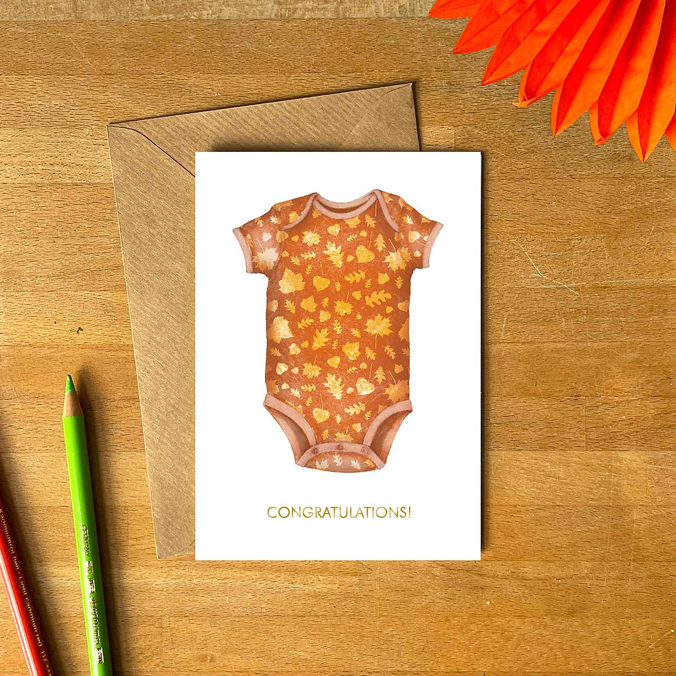 white greetings card with orange baby romper with autumn leaves pattern and congratulations text underneath, kraft envelope