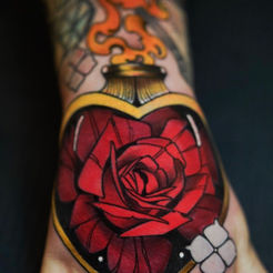 Heart-shaped rose tattoo, gold edging, with beautiful deep red rose, Cover Up Tattoo Artist Near Me.