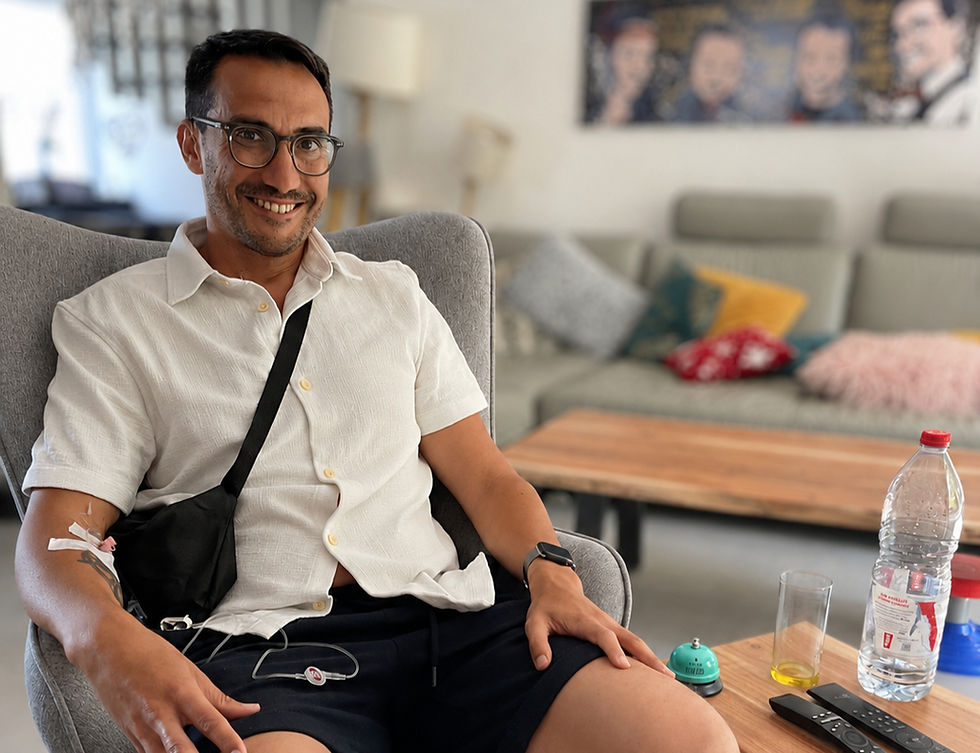 Sébastien assis dans un fauteuil avec l'air fatigué et un cathéter au bras