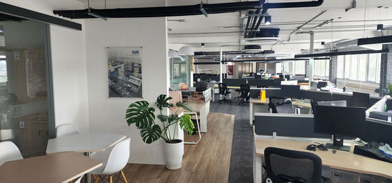 Open-plan workspace at Dürr Thailand with rows of modern desks, ergonomic seating, exposed ceiling services and large windows bringing natural light into the office.