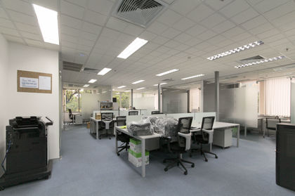 Open plan workstation area with ergonomic seating and modern lighting.