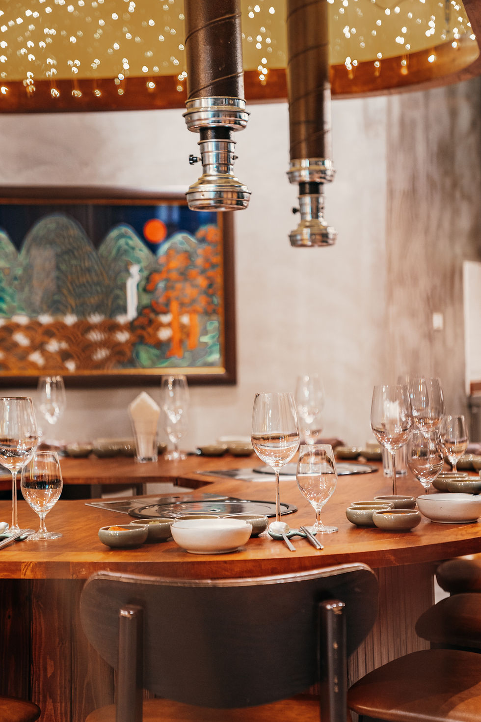 Private dining table with built-in Korean grill surrounded by timber panelling at Banjoo restaurant in Bangkok.