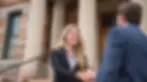 Attorney shaking hands with a client outside the courthouse in Evans, Georgia, symbolizing a successful legal outcome.