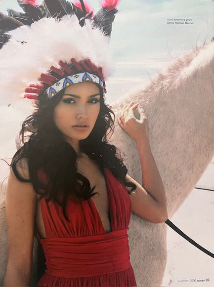 Candice Neill, Native Indian wearing an native headpiece near white horse on the beach