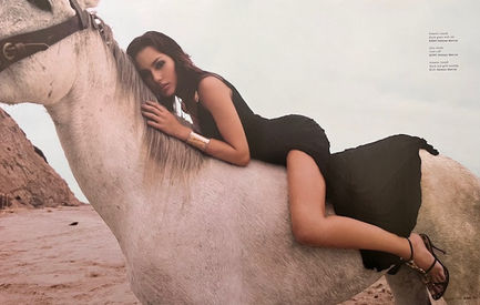 Candice Neill, model, riding a white horse on the beach - editorial fashion shoot