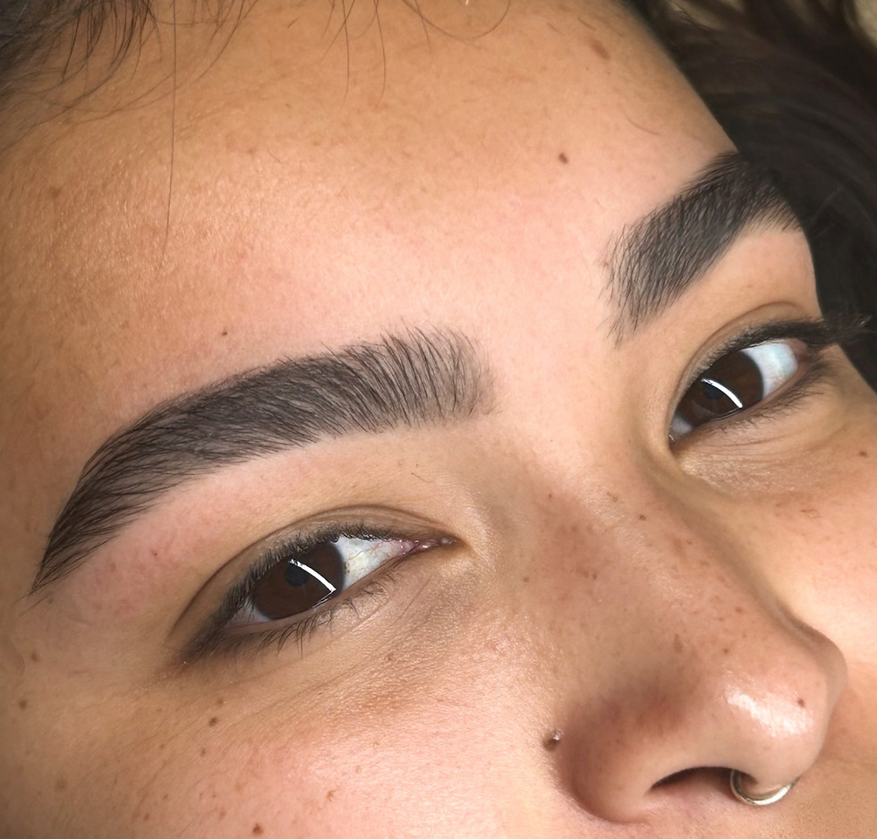 Young woman showing defined natural eyebrow lamination results at Wax N' Blush organic brow and lash boutique East Village Long Beach