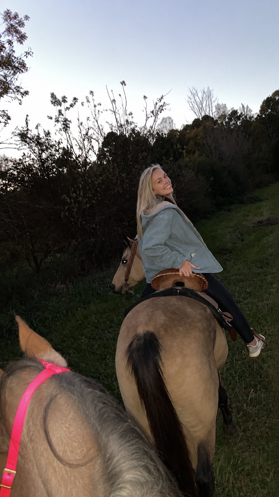 Bree riding a horse and smiling back toward the camera