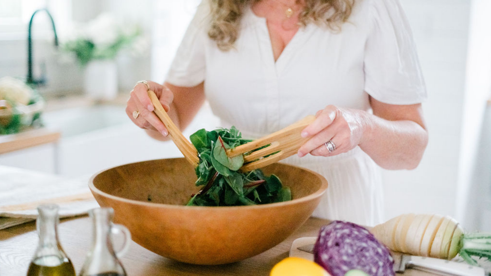 salad being mixed in a bowl