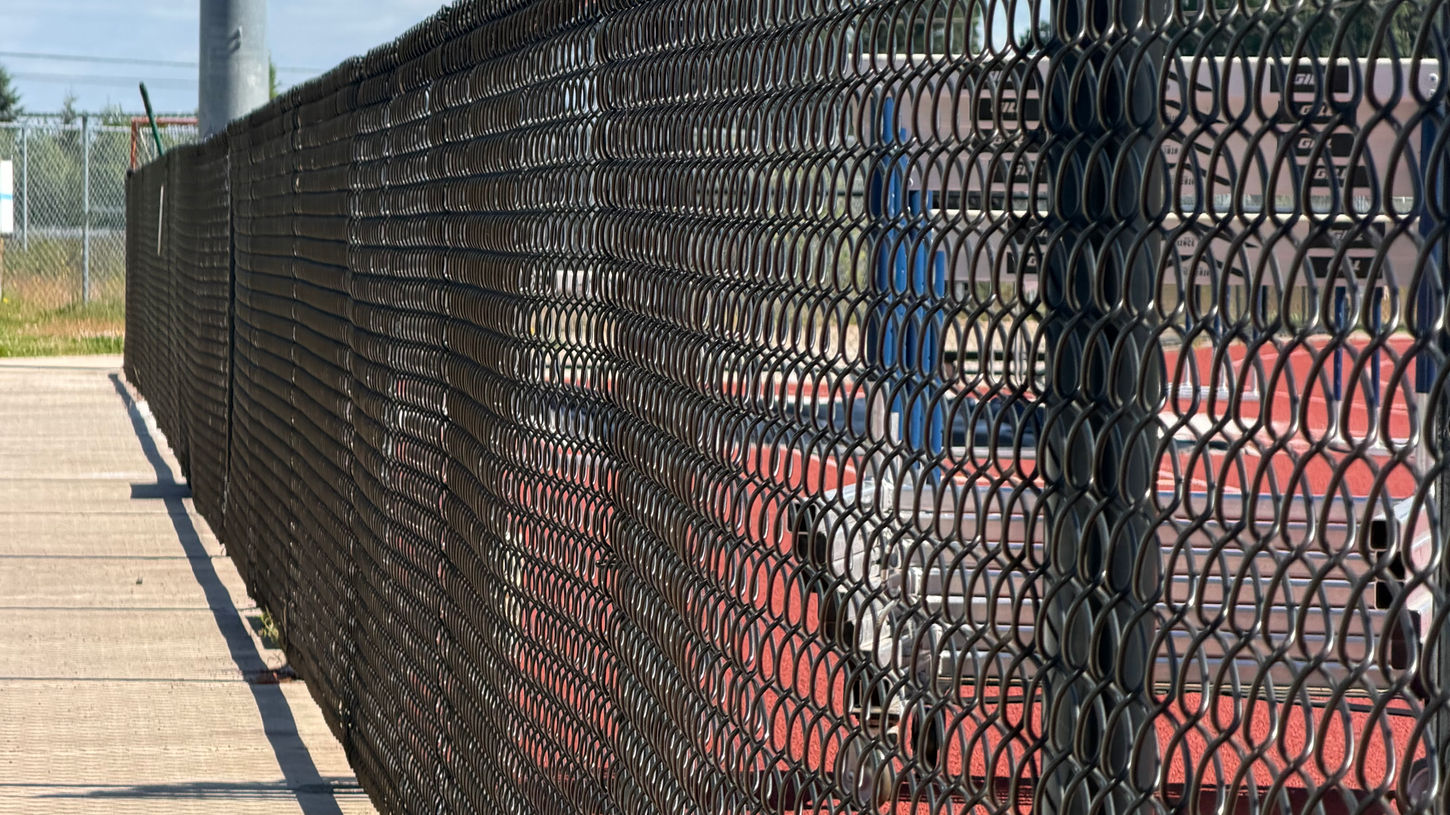 Black chain-link fence installed along a track walkway in Salem Oregon