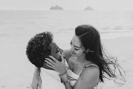 Newly engaged couple celebrating after proposal on Lanikai Beach in black and white photo
