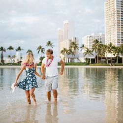 a Couple frolics through the water during their waikiki beach photo shoot