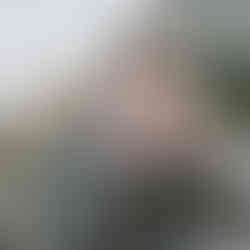 Groom rolling a cigarette during editorial-style wedding portraits in Rome near the Colosseum.