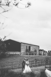 Jordan and Alexa kissing in front of a rustic barn.