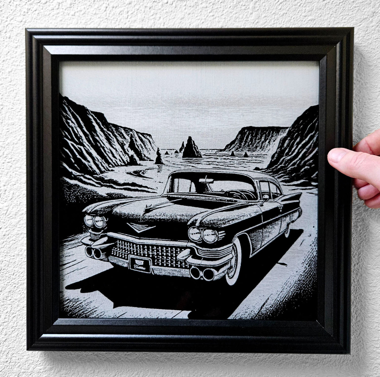 1959 Cadillac with the ocean and cliffs in the background in a black frame