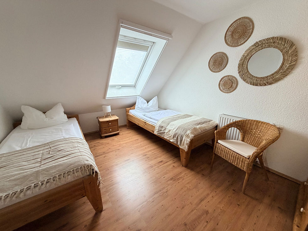 Schlafzimmer im Ferienhaus Kogge in Zingst mit zwei Einzelbetten.