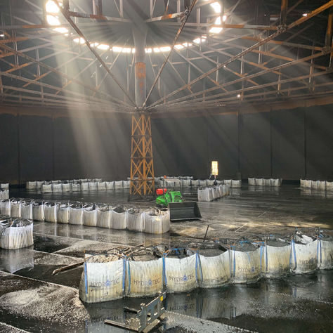 Industrial waste bags lined up inside a clean tank ready for collection.