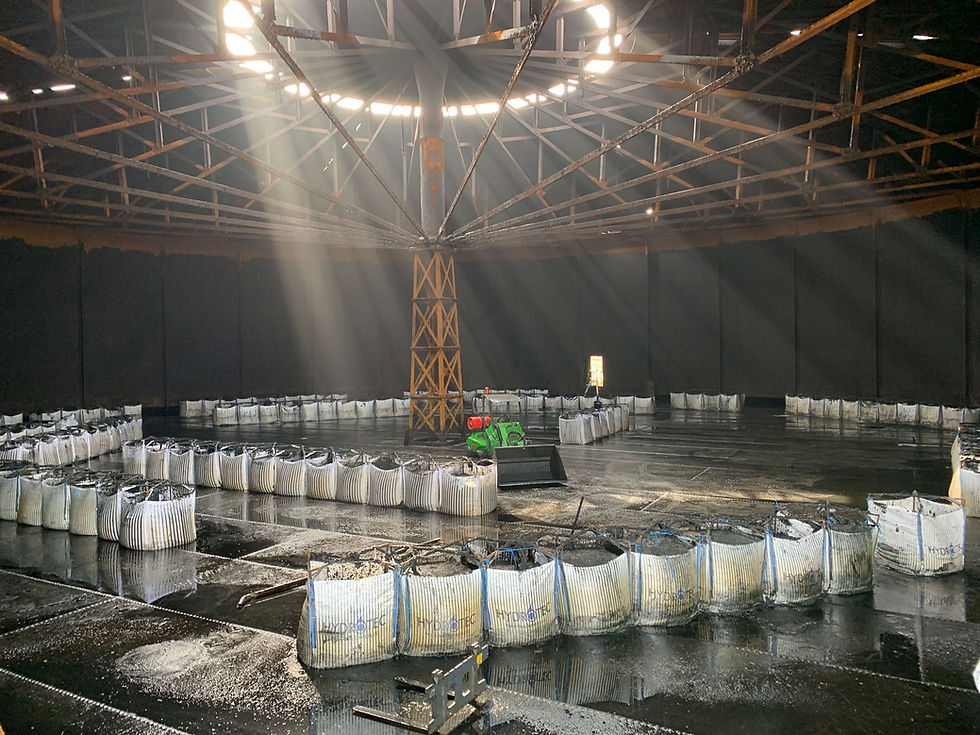 Industrial waste bags lined up inside a clean tank ready for collection.
