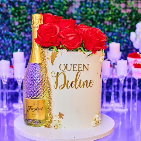 Luxury birthday cake with red roses and a gold champagne bottle, designed for an upscale event in Long Island or NYC.