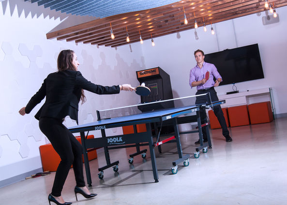 photography showing a business team playing ping pong table