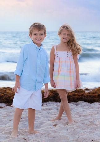 Two children smiling on the beach during an outdoor family photography session in South Florida