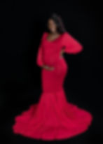 Expectant mother posing in a dramatic red mermaid maternity gown against a black studio background in Weston, FL.