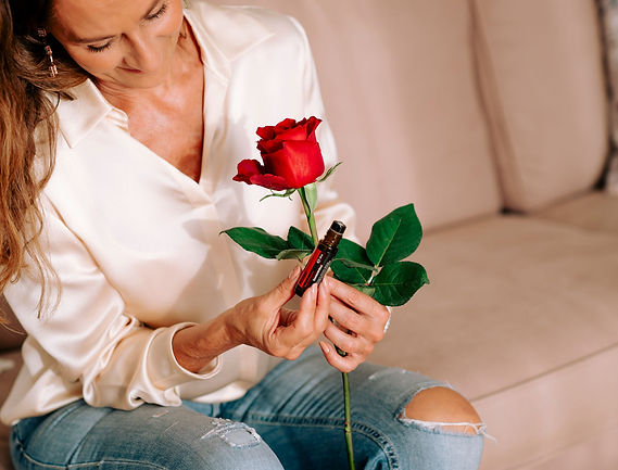 Sabine hält ätherisches Öl und Rose in der Hand