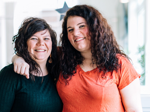 Daughter standing with her arm around mother