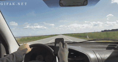 distracted driver with text messages blocking his view out of his front mirror
