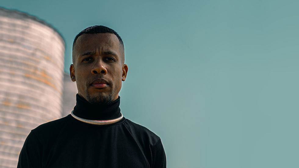 Alexandre Roiz Negro artista da Dança, foto do rosto, com camiseta gola alta preta e colar dourado