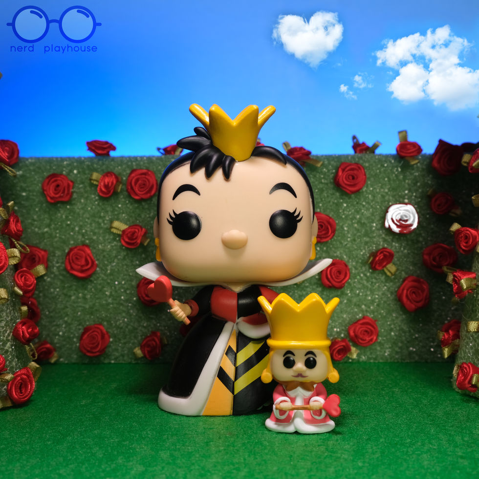Creative toy photography of Funko POP King and Queen of Hearts standing in their garden with one rose not painted red.