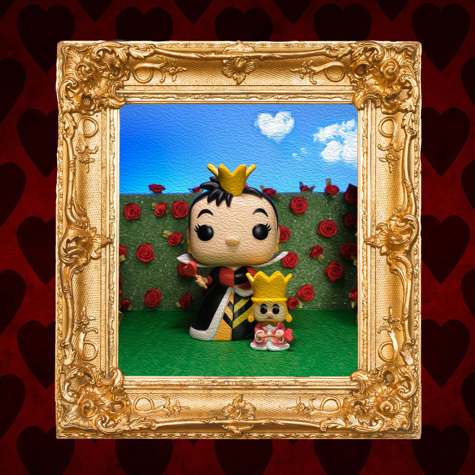 Creative toy photography of Funko POP King & Queen of Hearts in a framed picture of them standing in their rose garden. The framed picture hangs on a red wall with dark red hearts.