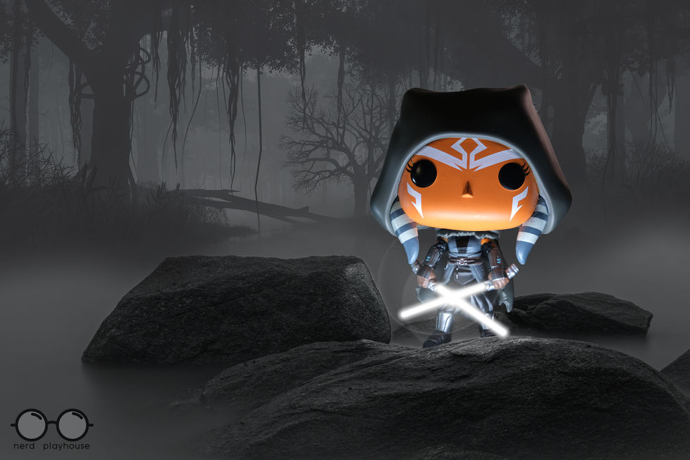 Creative toy photography of Funko POP Ahsoka, wielding two white lightsabers, standing in a dark, foggy swamp.