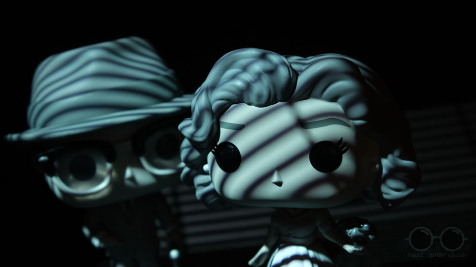 Creative toy photography of grayscale Funko POP Wanda and Vision using gobos to give a film noir aesthetic.