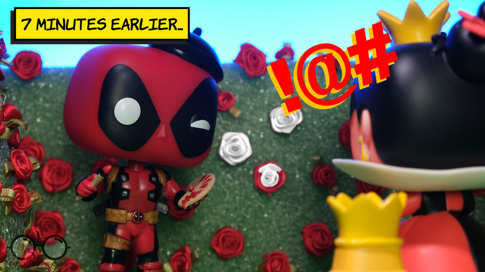 Creative toy photography of Funko POP Deadpool as an artist painting the roses red in the Queen of Heart's garden. The Queen of Hearts is furious.