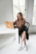 Woman sitting at a desk working on her marketing on a laptop.