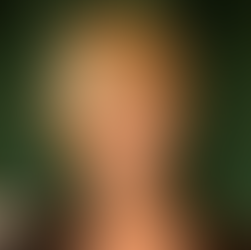 Front view of a short, heavily layered blonde bob with long side-swept bangs and lots of volume at the crown.