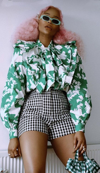 Femme portant une chemise à col lavallière fleurie avec un short vichy