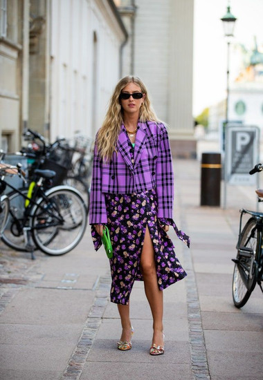 Femme portant un blazer à carreaux avec une jupe fleurie dans la même couleur