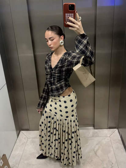 femme portant un top à carreaux et une jupe fluide à pois