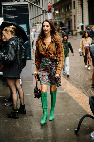 femme portant une chemise à carreaux avec une jupe fleurie et des bottes vertes