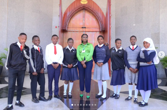 Wide-angle view of students standing together after an educational visit in Dodoma.