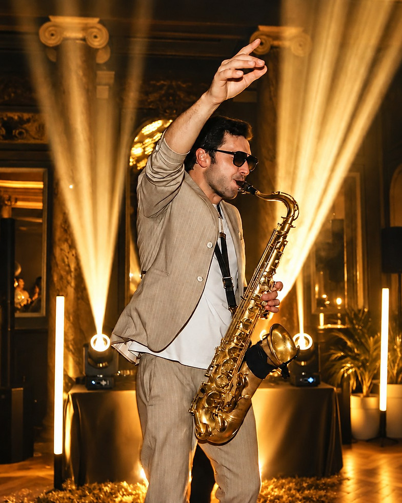 Maxime au saxophone sur le dancefloor, sous les faisceaux lumineux