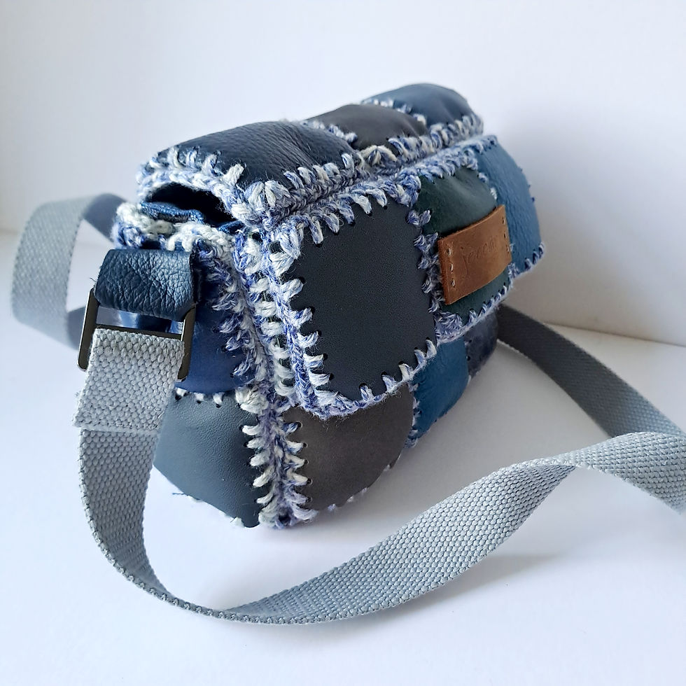 Thumbnail: Small rectangular crossbody bag made from padded reclaimed leather squares in blue and grey, with a grey adjustable strap.