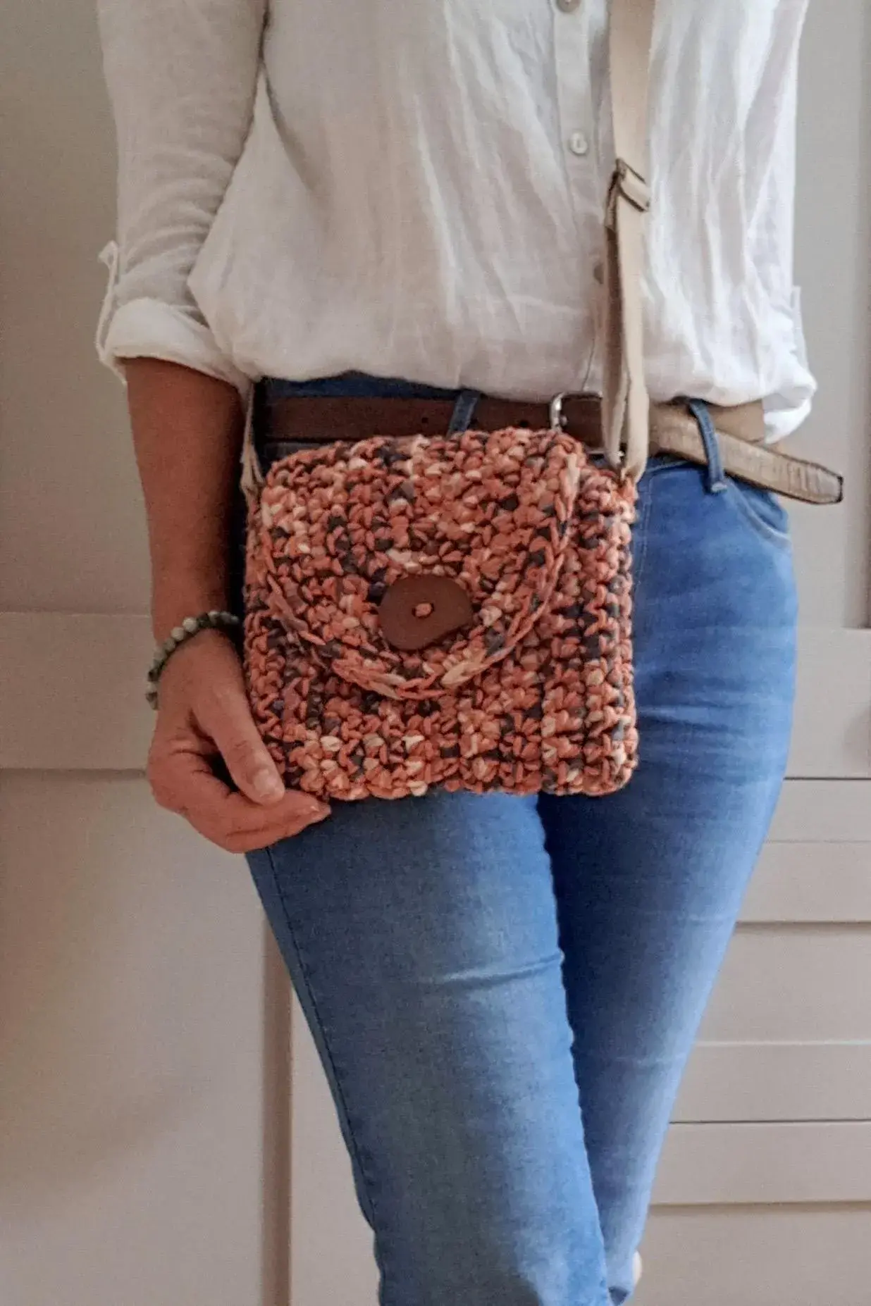 Burnt orange mixed fibre tweedy & textured little bag. Feature button & webbing strap. Autumn mixed shades. On model