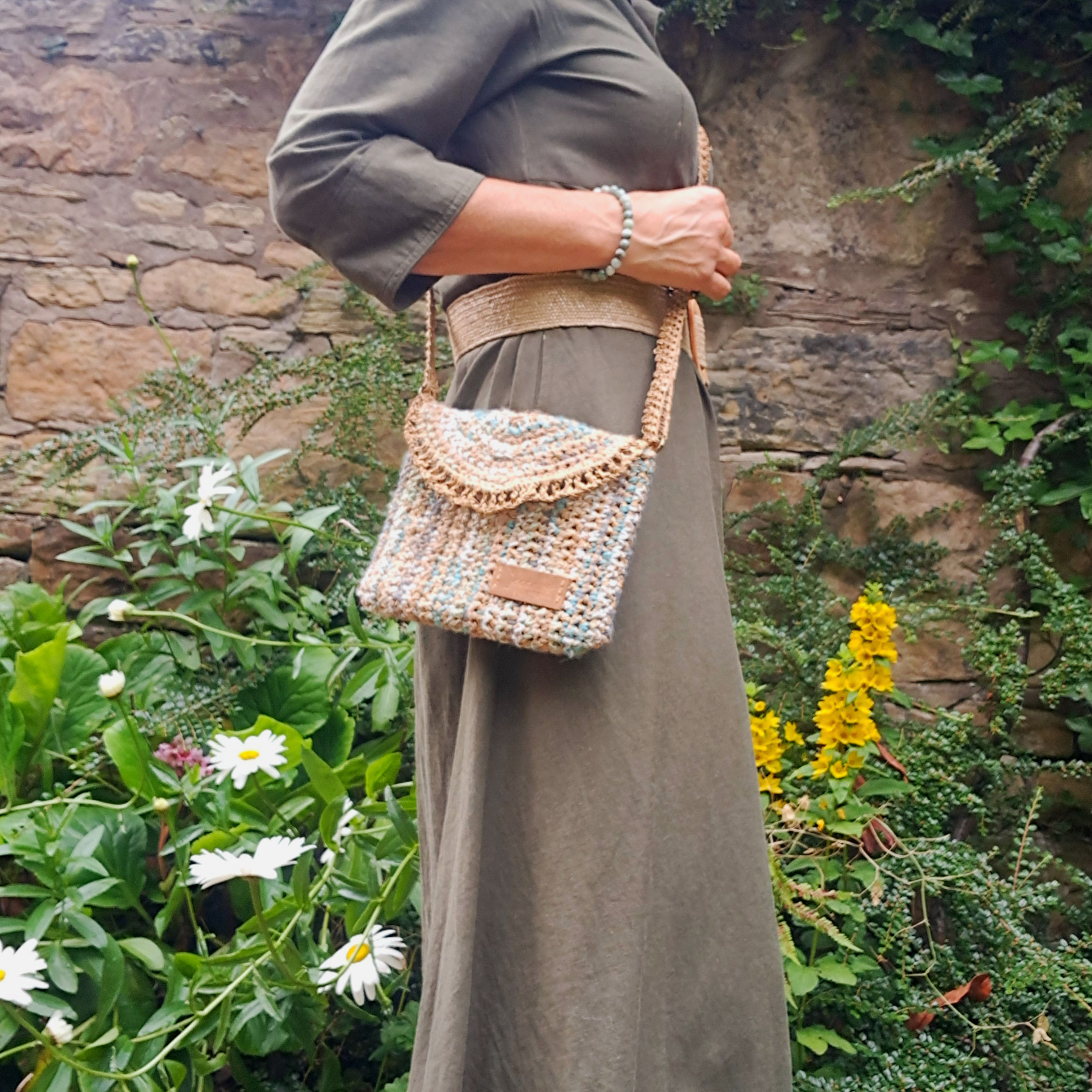 Little textured envelope shoulder bag in natural raffia & wool. Textured effect. Muted colours. Raffia frill & strap on model