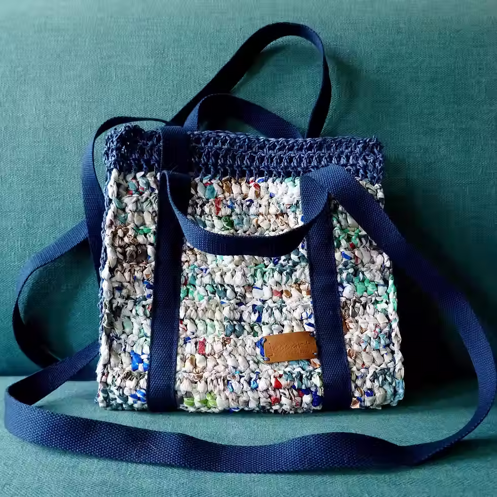 Structured handbag from recycled plastic bags & raffia twine. Mainly white with blue. Webbing handles & straps