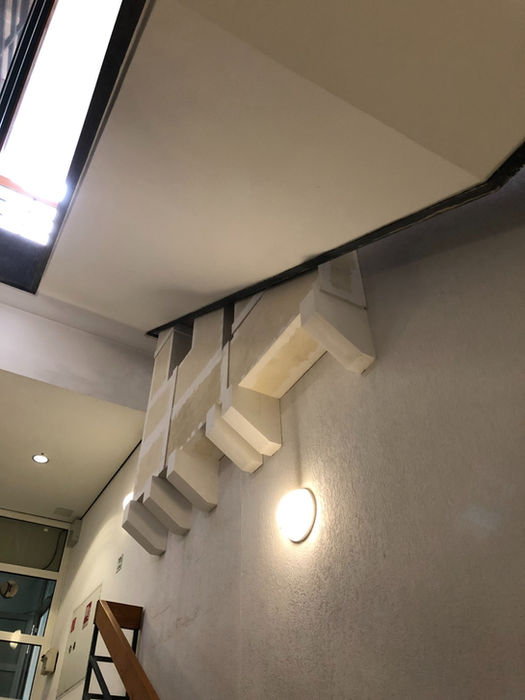 Weiße Promat-Platten bilden eine Brandschutzabschottung an der Wand mit Beleuchtung und Kabeln
